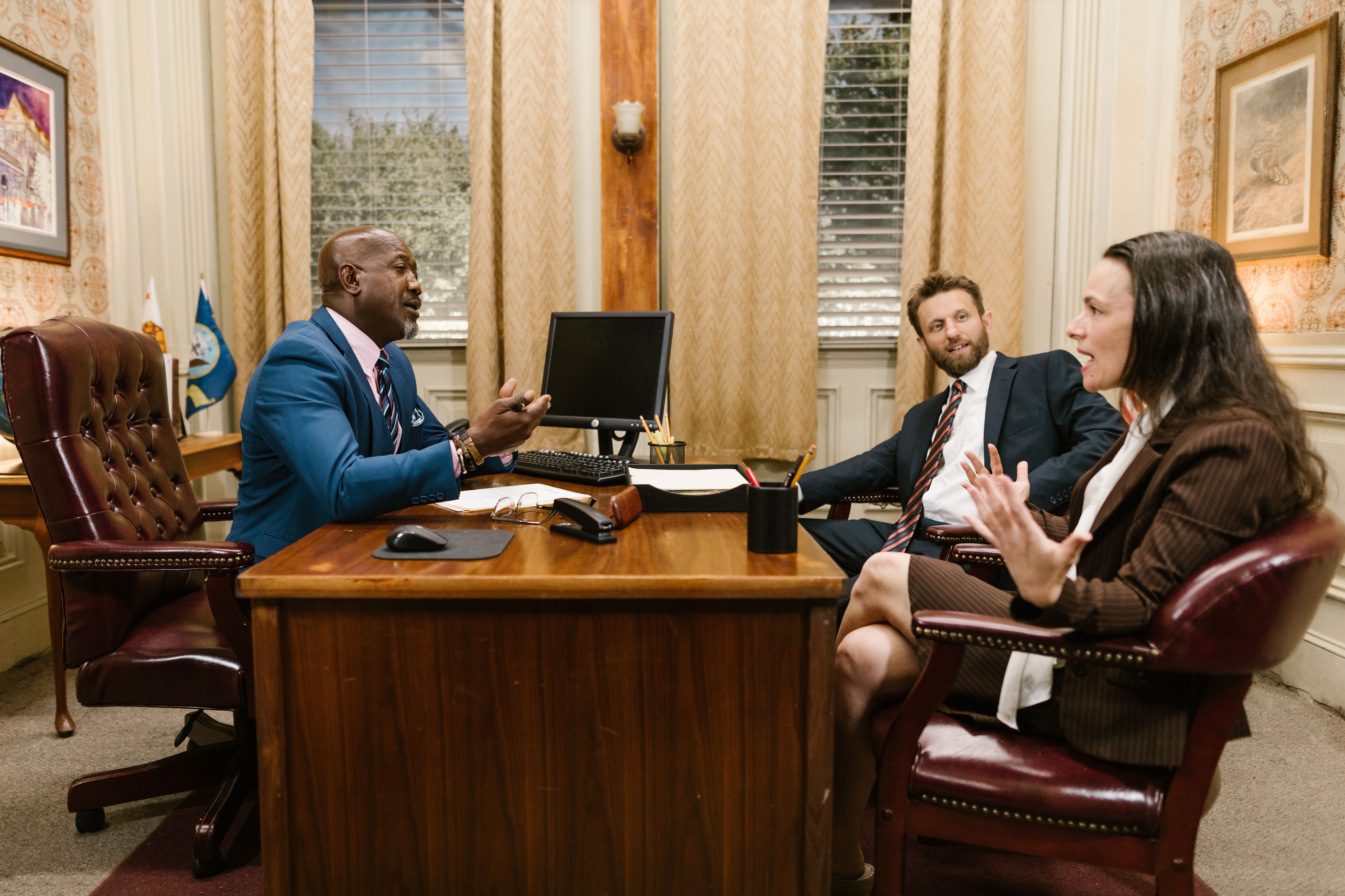 Three attorneys in a legal discussion at a well-appointed law firm office