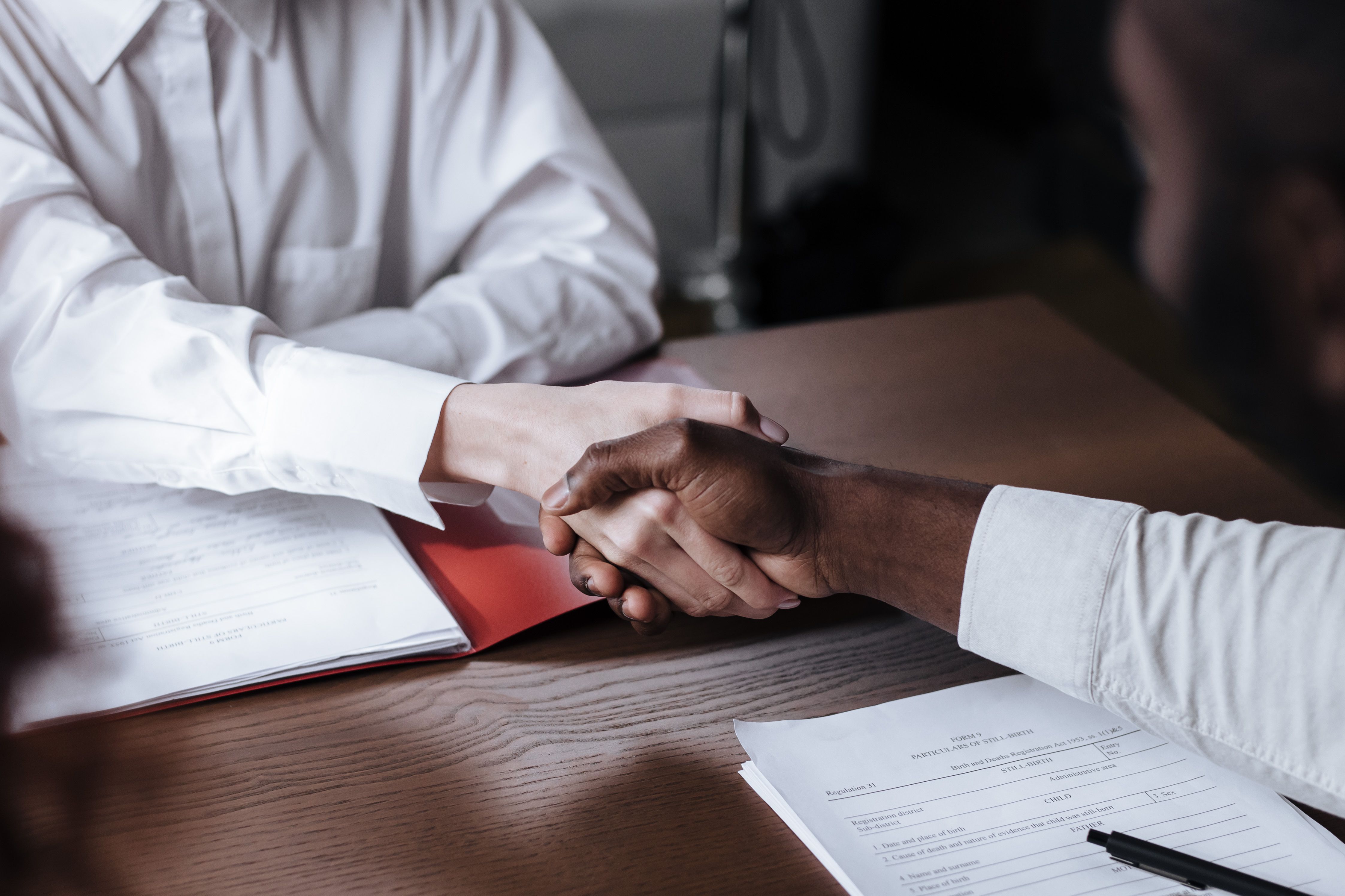 Two people shaking hands over documents, symbolizing a litigation funding agreement