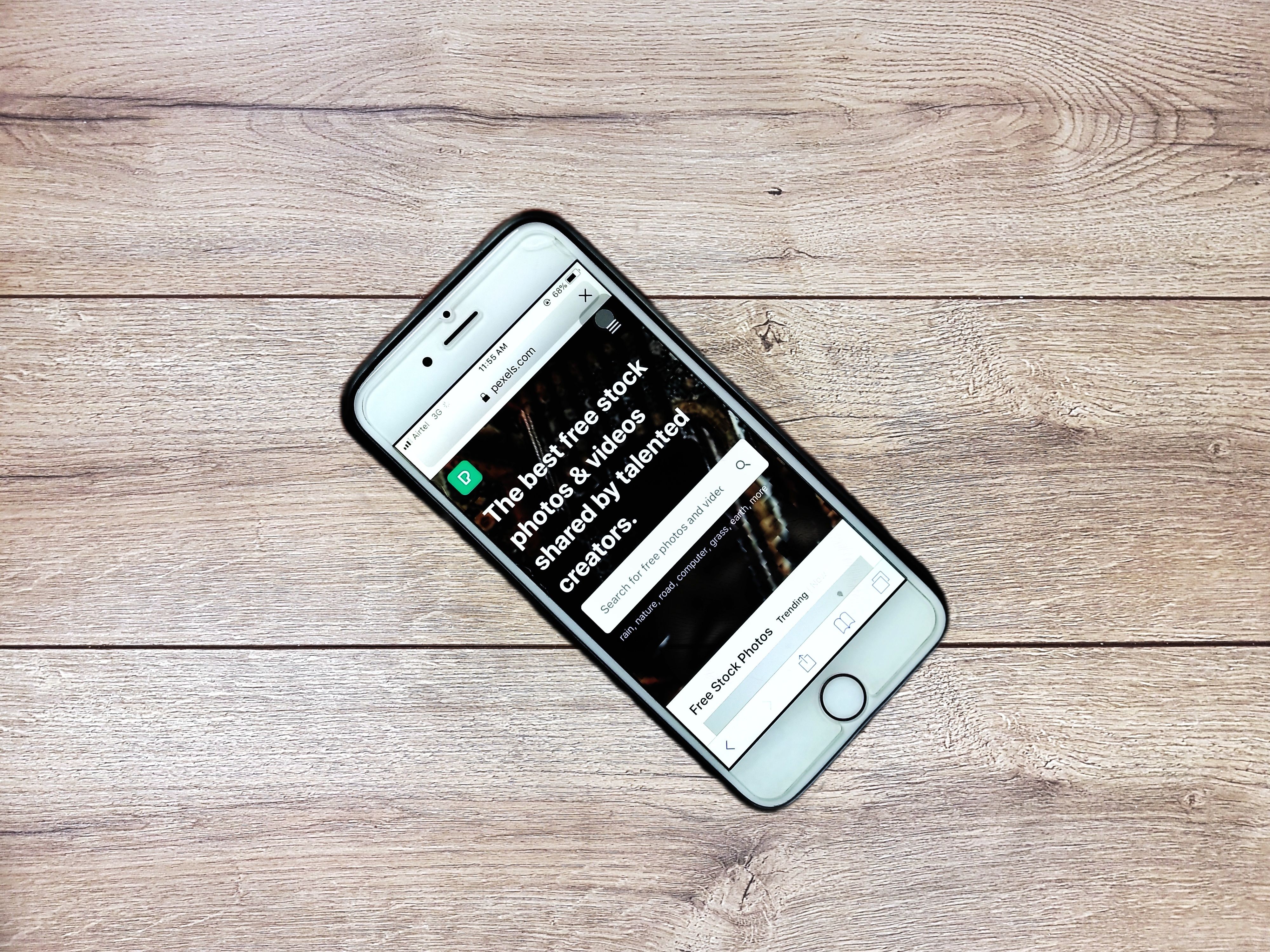 Smartphone on a wooden table displaying a website on its mobile browser